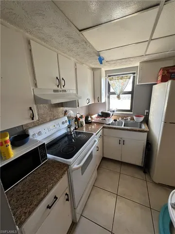 a kitchen with a sink a stove top oven a counter space and cabinets