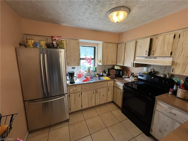 a kitchen with stainless steel appliances granite countertop a refrigerator sink and cabinets