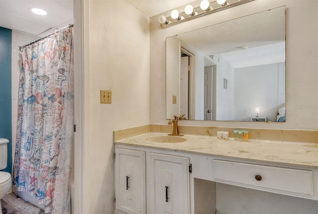 6157 Midnight Pass Road, Unit E63 Sarasota, FL 34242 - Photo 25 of 61 a bathroom with a granite countertop sink and a mirror