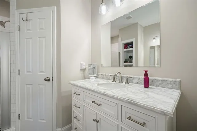 a bathroom with a granite countertop sink and a mirror