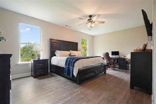 a bedroom with a bed and wooden floor