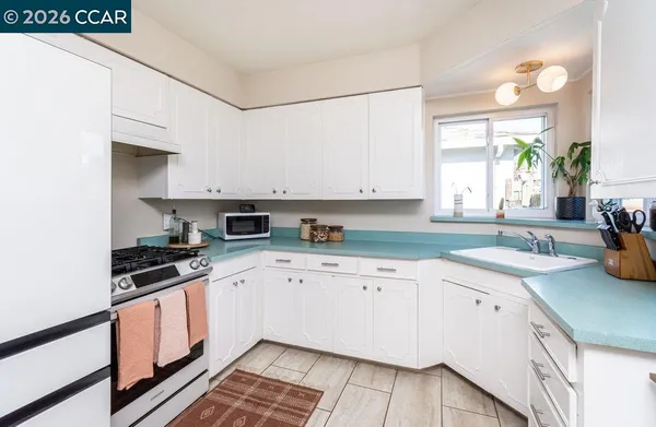 a kitchen with a sink stove top oven and cabinets