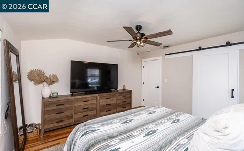 a bedroom with a bed and a flat screen tv