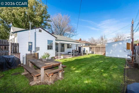 a view of a house with backyard sitting area and garden