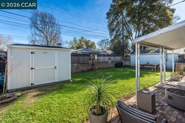a view of a backyard with couches plants and large tree