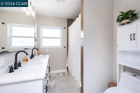 a bathroom with a sink a toilet and a window