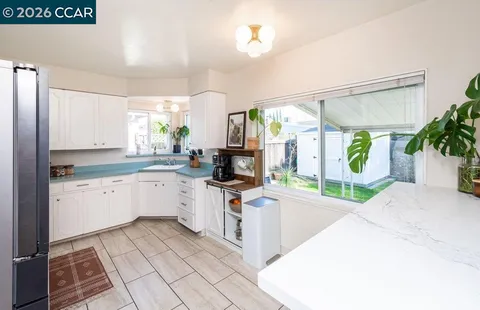 a kitchen with a sink a counter top space cabinets and stainless steel appliances