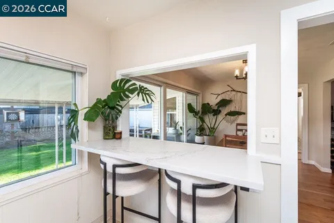 a view of a dining room with furniture and a potted plant
