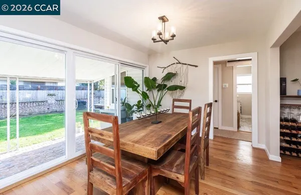 a dining room with furniture a chandelier and wooden floor