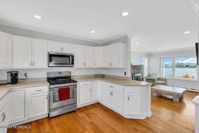 a large kitchen with granite countertop a sink and dishwasher a stove top oven with wooden floor