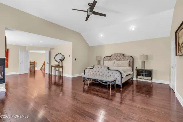 a view of an empty room and kitchen view with wooden floor