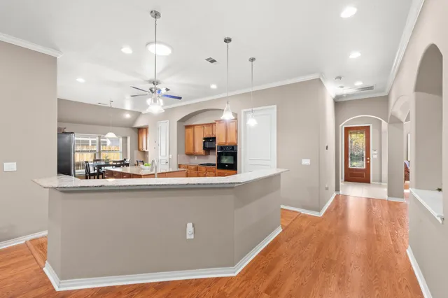a view of a kitchen with kitchen island stainless steel appliances sink and living room view