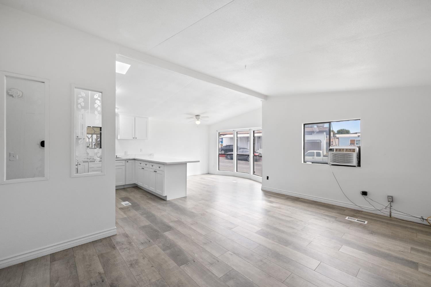 8300 Kern Canyon Road, Unit 156 Bakersfield, CA 93306 - Photo 11 of 40 an empty room with wooden floor and windows