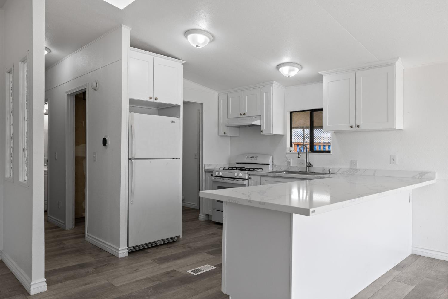 8300 Kern Canyon Road, Unit 156 Bakersfield, CA 93306 - Photo 14 of 40 a kitchen with stainless steel appliances granite countertop a refrigerator a sink a stove a microwave and white cabinets