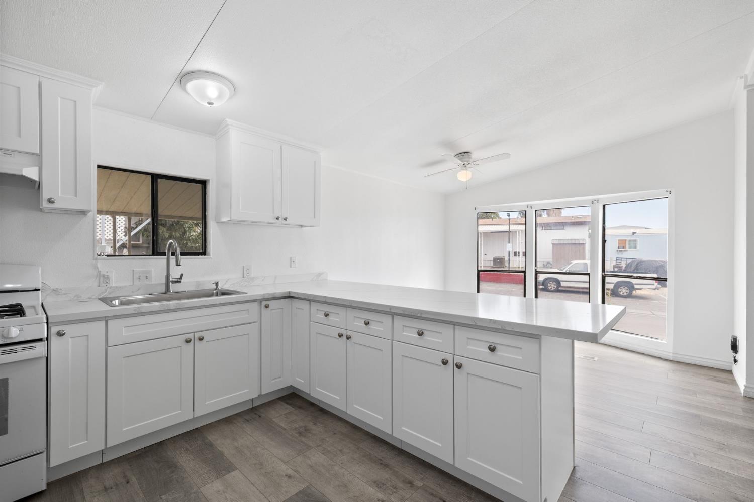8300 Kern Canyon Road, Unit 156 Bakersfield, CA 93306 - Photo 17 of 40 a kitchen with white cabinets and sink