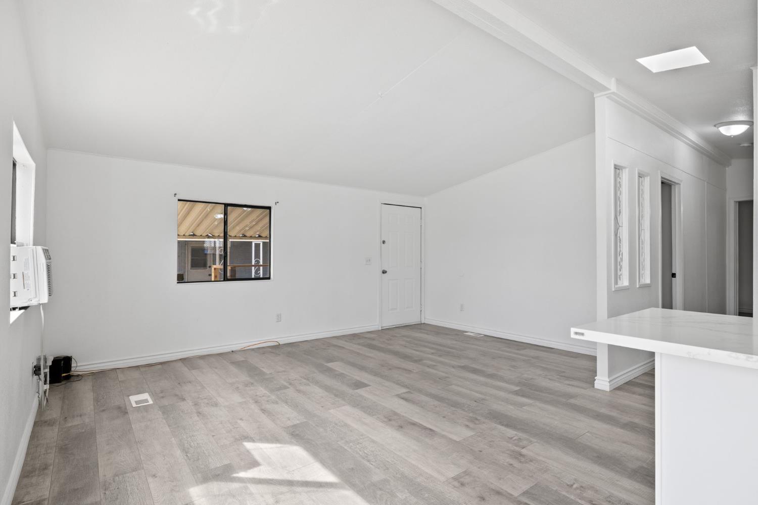 8300 Kern Canyon Road, Unit 156 Bakersfield, CA 93306 - Photo 7 of 40 a view of an empty room with wooden floor and a window