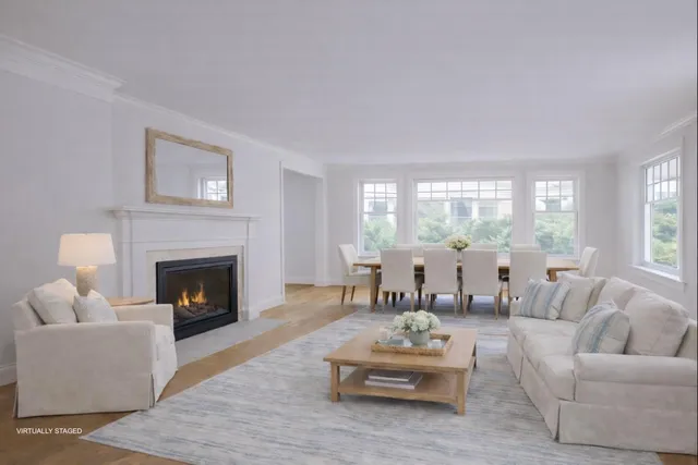 a living room with furniture fireplace and a large window