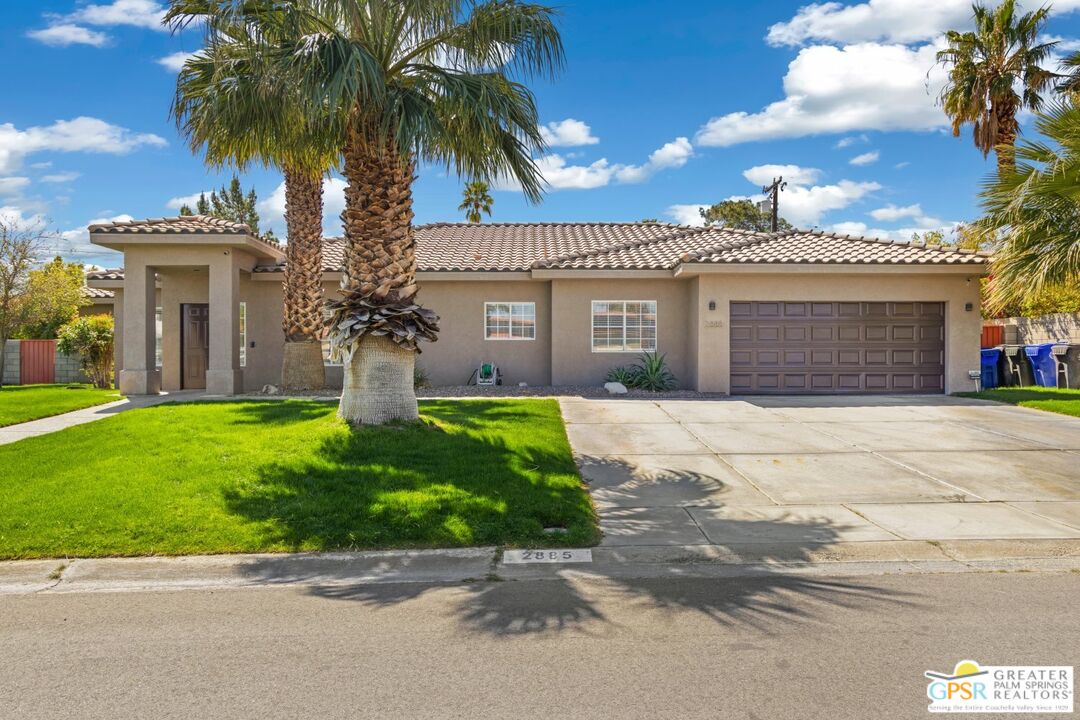 2885 East Sandia Road Palm Springs, CA 92262 - Photo 2 of 30 a front view of a house with a garden and palm trees