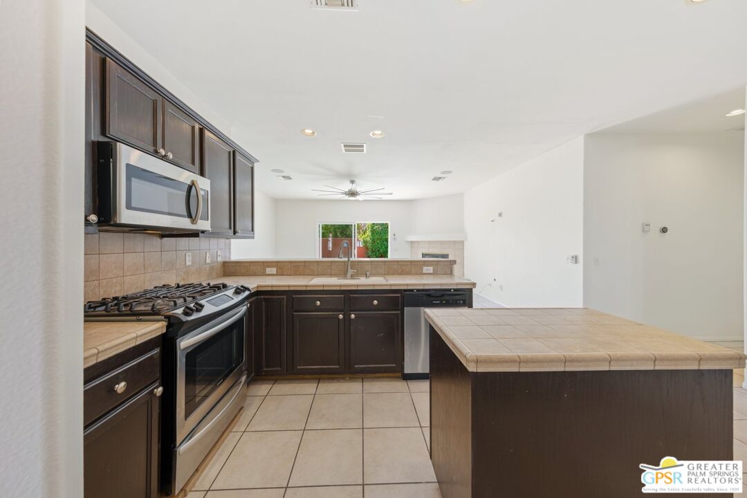 2885 East Sandia Road Palm Springs, CA 92262 - Photo 8 of 30 a kitchen with stainless steel appliances granite countertop a stove a sink and a microwave