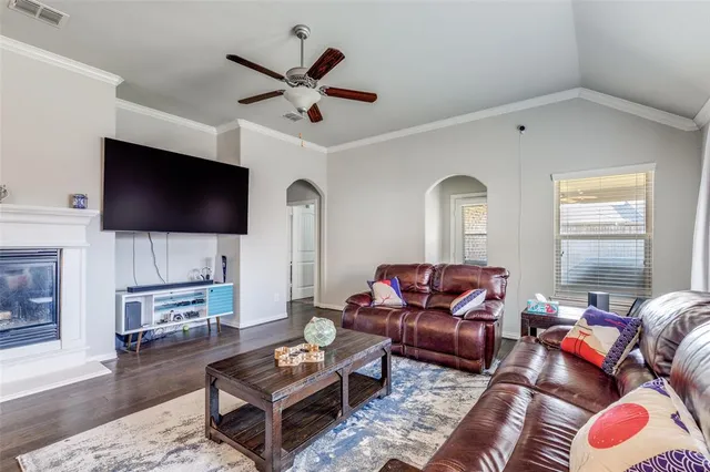 a living room with furniture a flat screen tv and a window