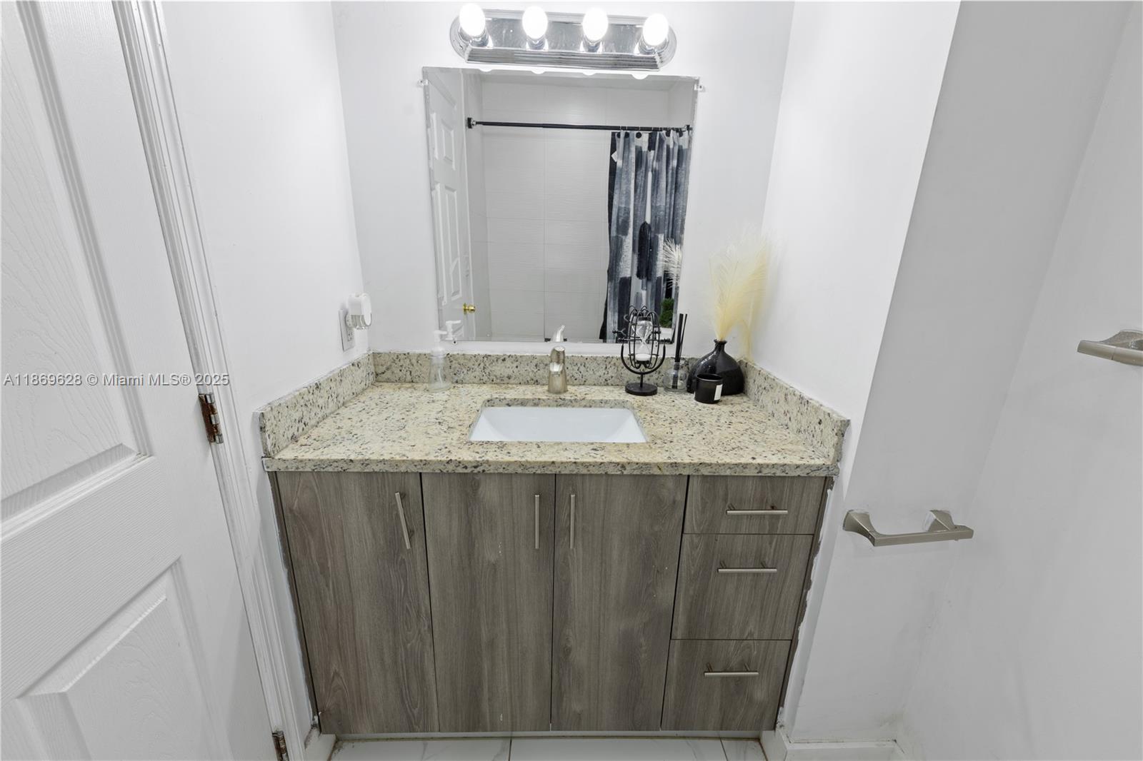 135 Northwest 6th Avenue Dania Beach, FL 33004 - Photo 15 of 26 a bathroom with a granite countertop sink and a mirror