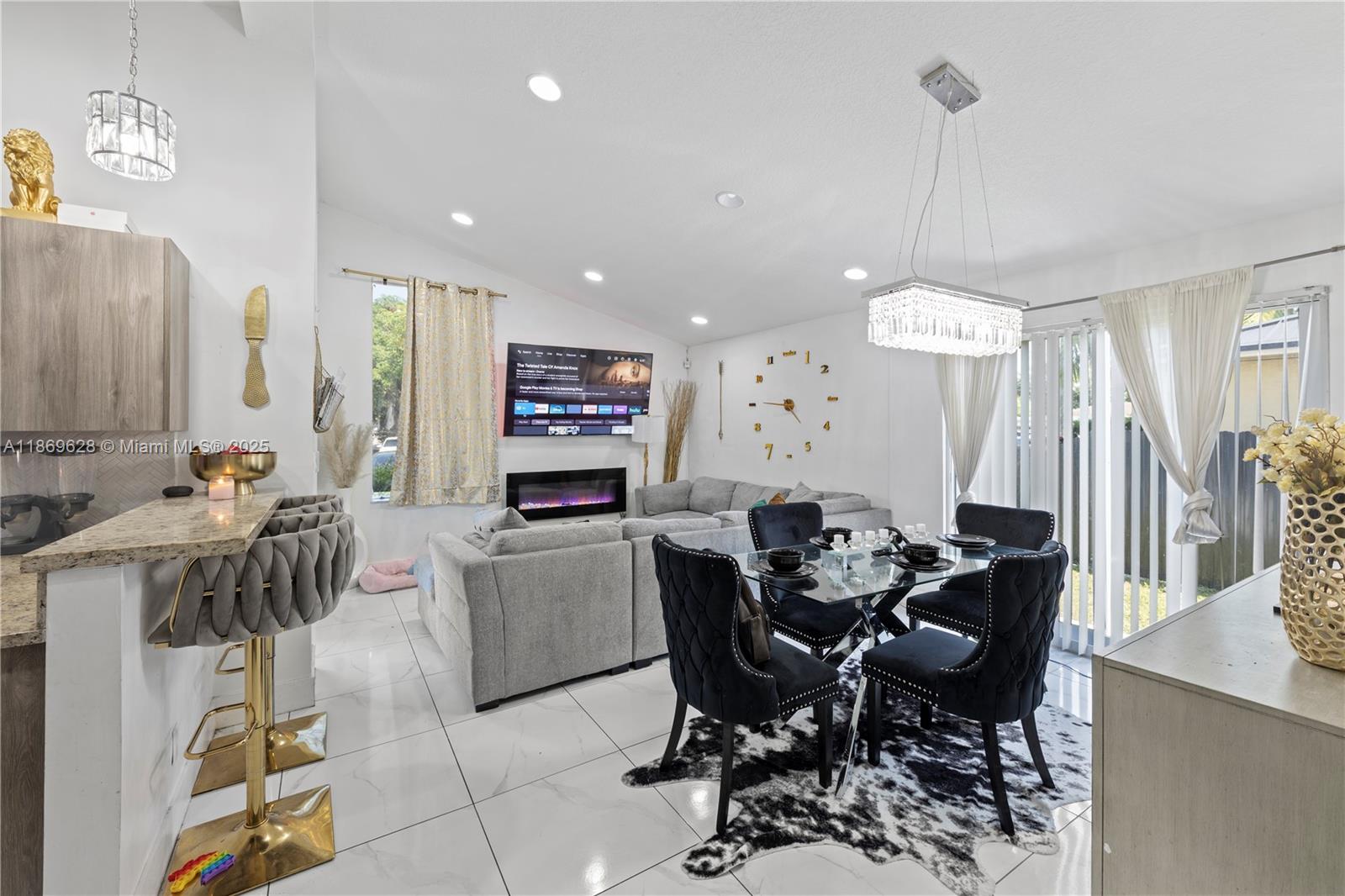 135 Northwest 6th Avenue Dania Beach, FL 33004 - Photo 4 of 26 a view of a dining room and livingroom with furniture wooden floor a rug a painting and a chandelier