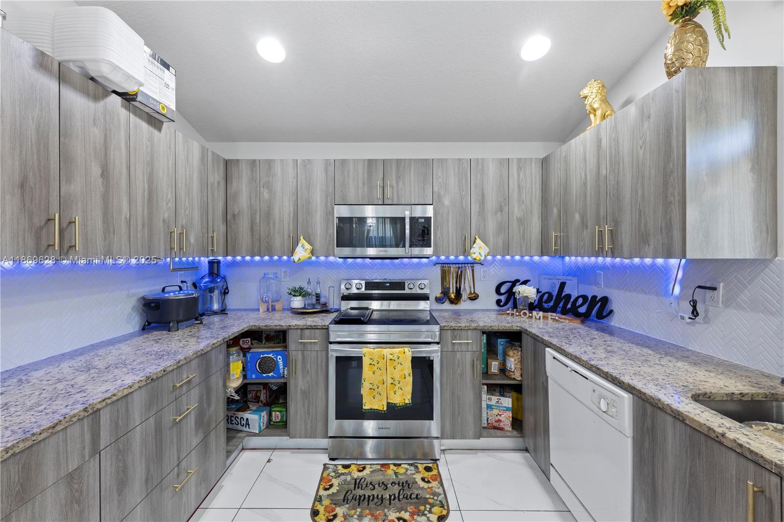135 Northwest 6th Avenue Dania Beach, FL 33004 - Photo 5 of 26 a kitchen with a stove top oven sink and cabinets