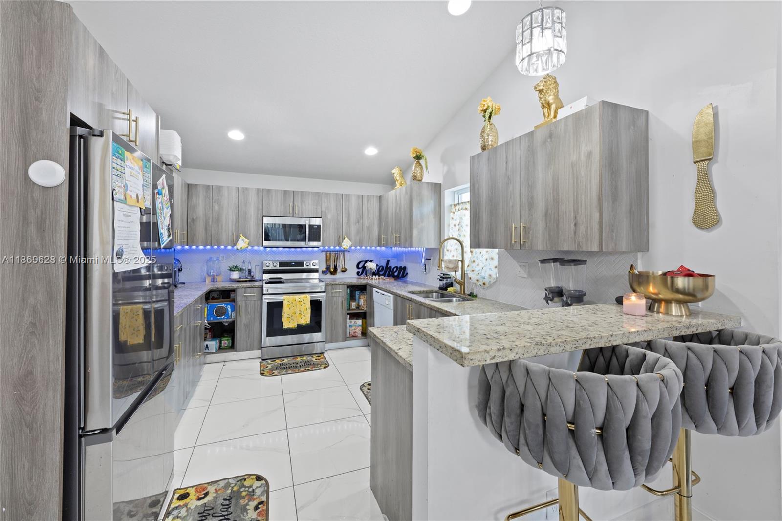 135 Northwest 6th Avenue Dania Beach, FL 33004 - Photo 6 of 26 a kitchen with stainless steel appliances granite countertop a sink refrigerator and cabinets