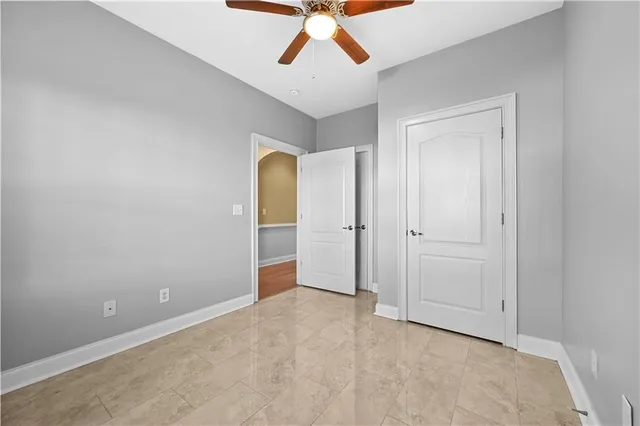 an empty room with closet and a chandelier fan
