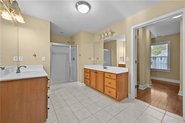 a spacious bathroom with a granite countertop sink a mirror and a bathtub