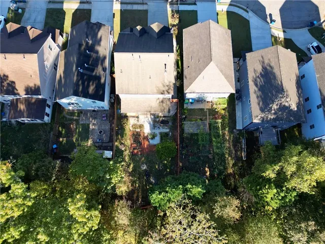 an aerial view of a house with a yard and large trees