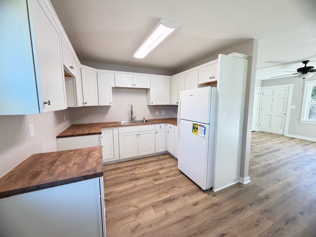 128 Stewart Street Cowan, TN 37318 - Photo 8 of 14 a kitchen with a refrigerator a stove top oven a sink and dishwasher with wooden floor
