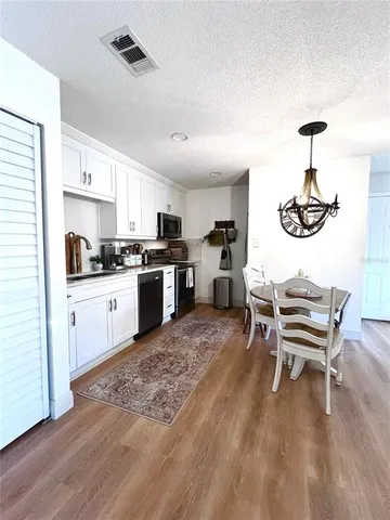a kitchen with a sink cabinets and wooden floor