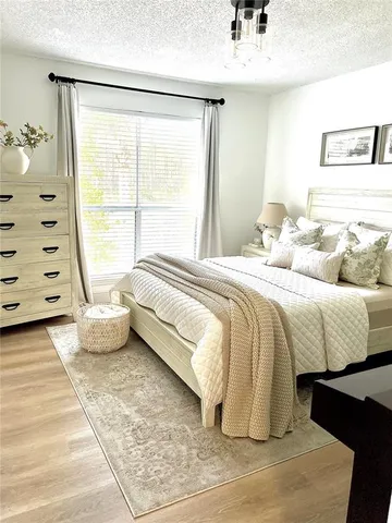 a spacious bedroom with a bed and glass window