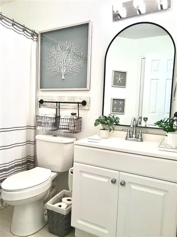 a bathroom with a toilet a sink and a mirror