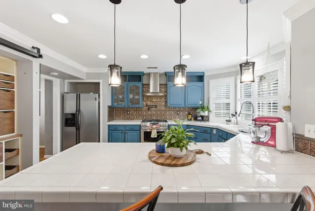 a kitchen with a refrigerator a oven and white cabinets