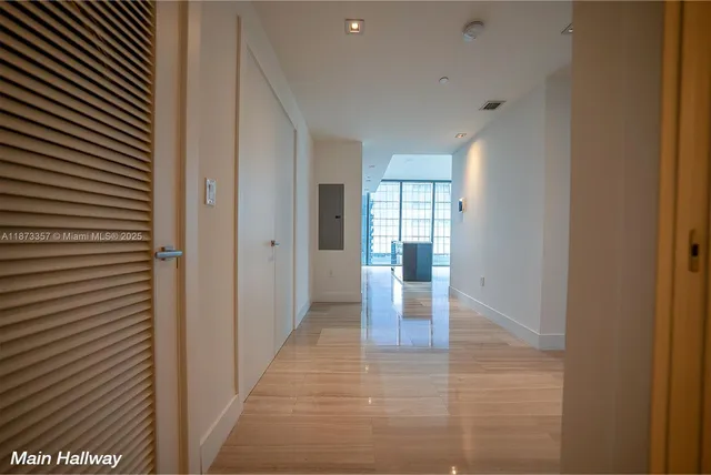 a view of hallway with livingroom and wooden floor