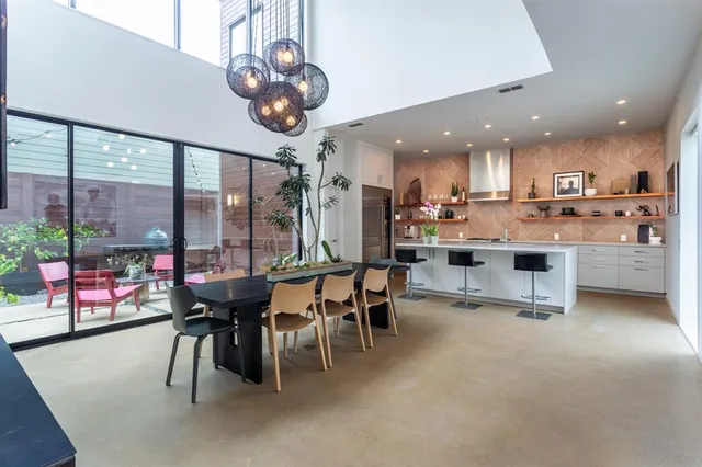 a room with stainless steel appliances lots of white furniture a window and a kitchen view