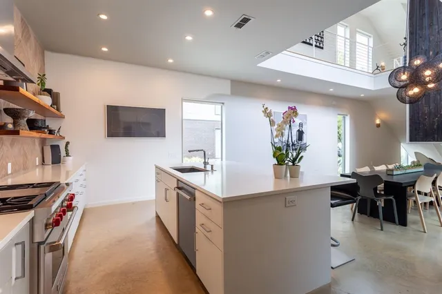 a kitchen with stainless steel appliances granite countertop a sink a stove and a refrigerator