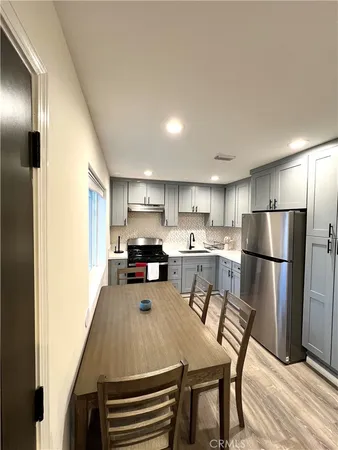 a kitchen with refrigerator and table