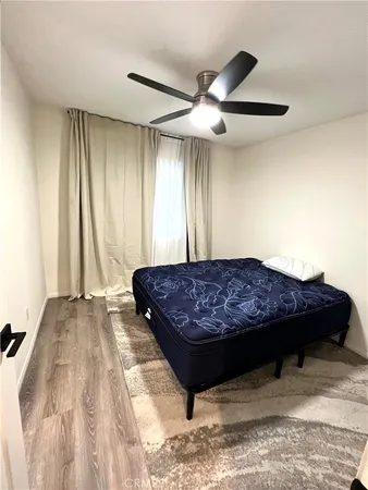 a bedroom with a bed dresser and a large window