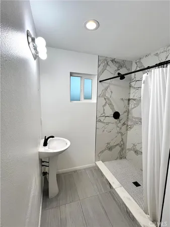 a bathroom with a shower a sink and a toilet