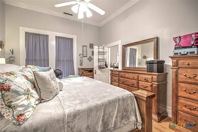 a bedroom with a bed and dresser with mirror