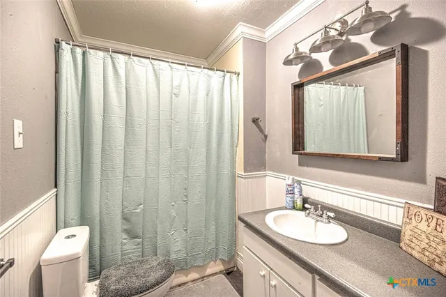 a bathroom with a granite countertop sink toilet a mirror and a shower