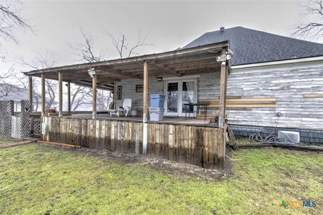 a view of a small house with a yard and sitting area