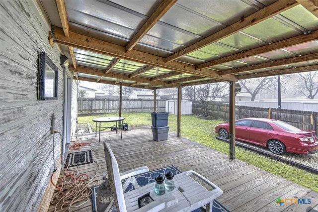 a view of a patio with a table chairs and a backyard