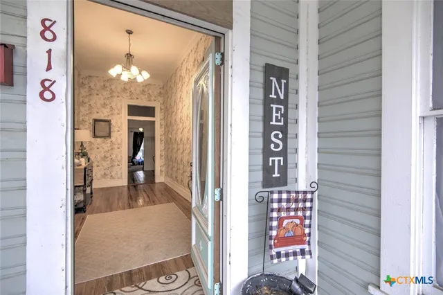 a view of a hallway and a livingroom with furniture