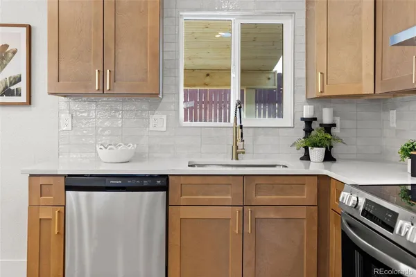 a kitchen with stainless steel appliances granite countertop white cabinets and a sink