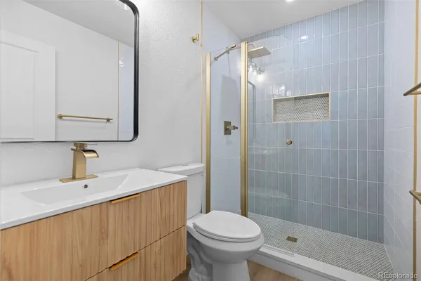 a bathroom with a sink a toilet and shower