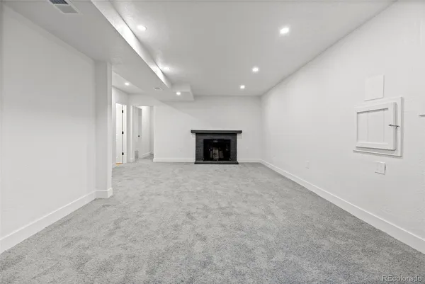 an empty room with fireplace and cabinet